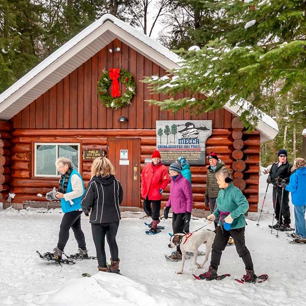 A group of people standing in front of a cabin 